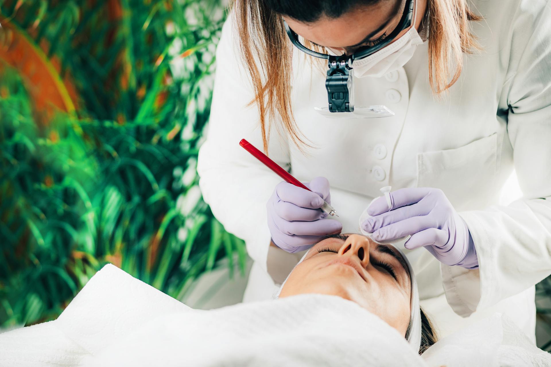 Aesthetician consulting with a client during a cosmetic treatment in a serene spa environment.