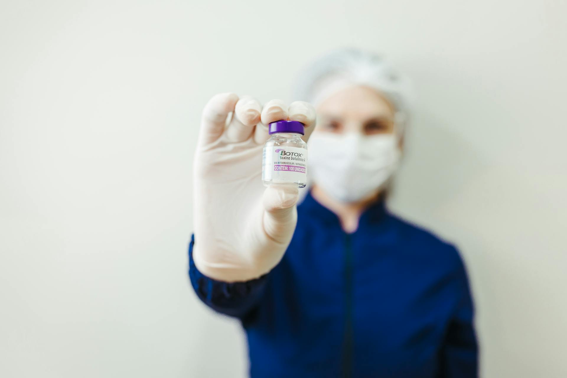 Medical provider holding a Botox vial in a clinical treatment setting