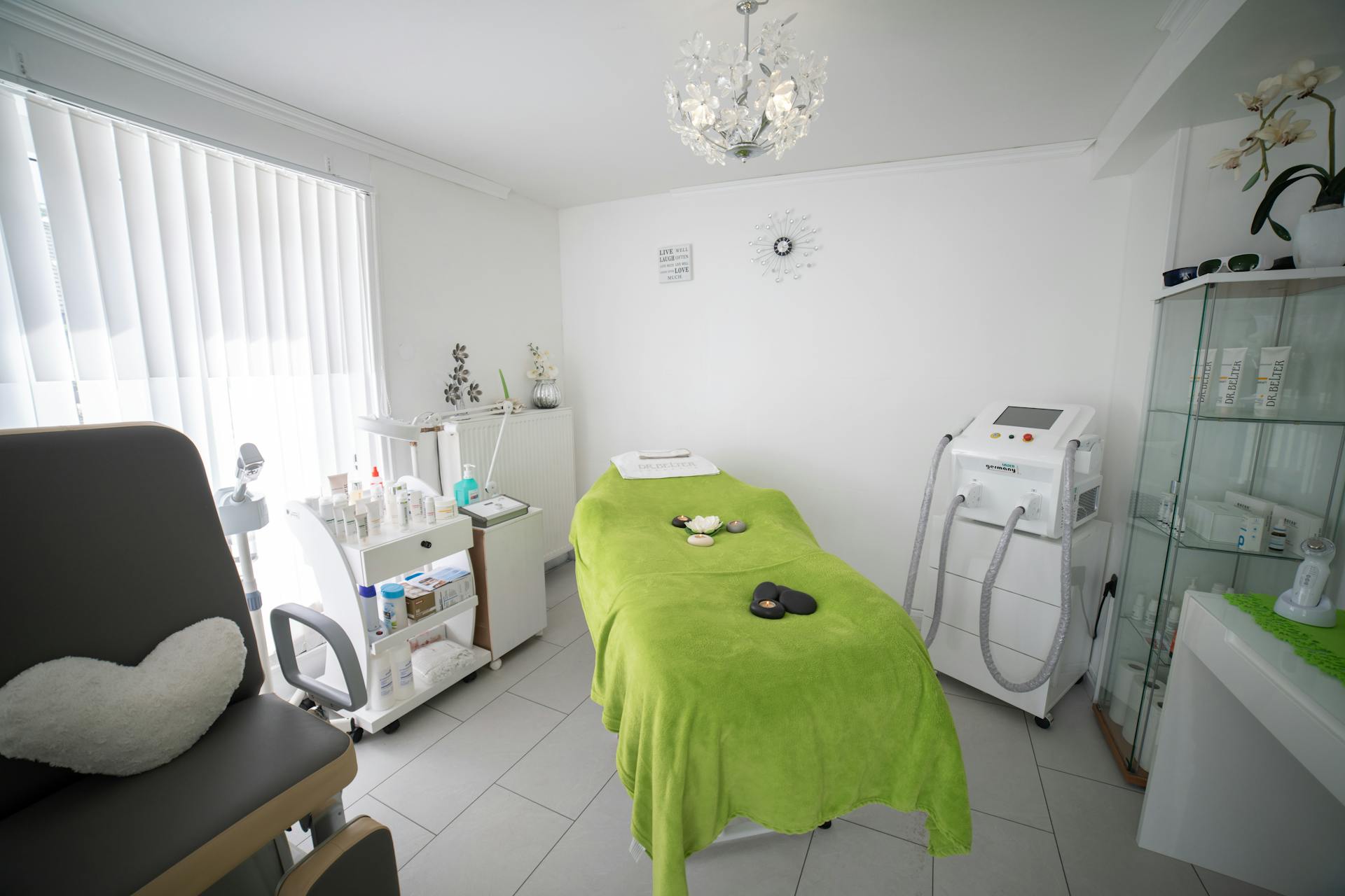 Modern medical spa treatment room with aesthetic equipment and lime-green treatment bed