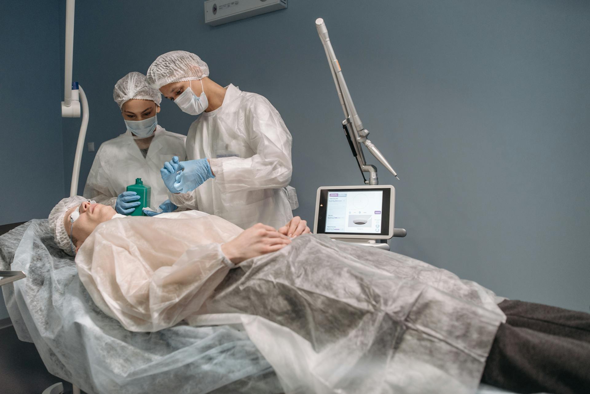 Two doctors administering a cosmetic treatment to a patient in a clinic setting.