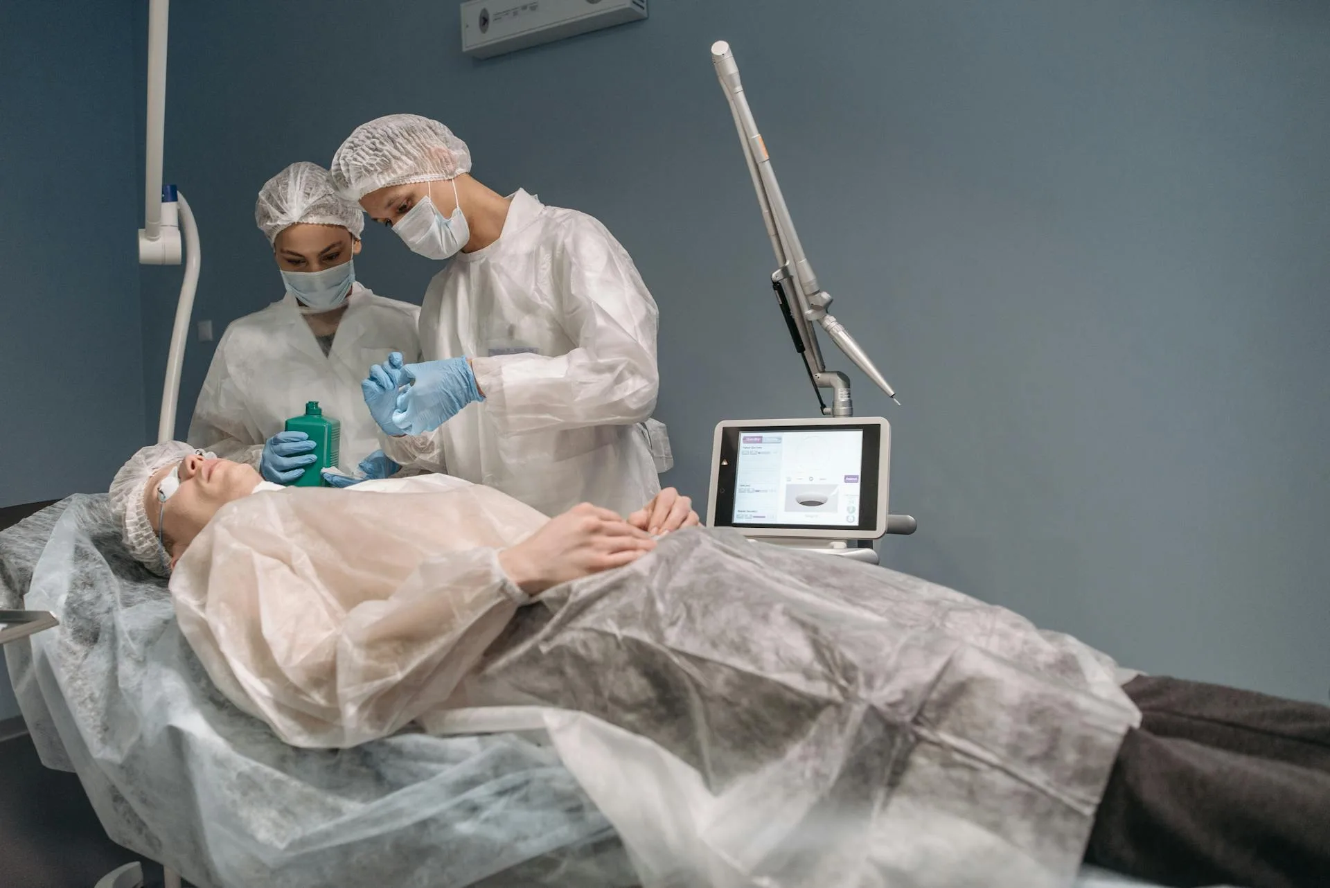 Two doctors administering a cosmetic treatment to a patient in a clinic setting.