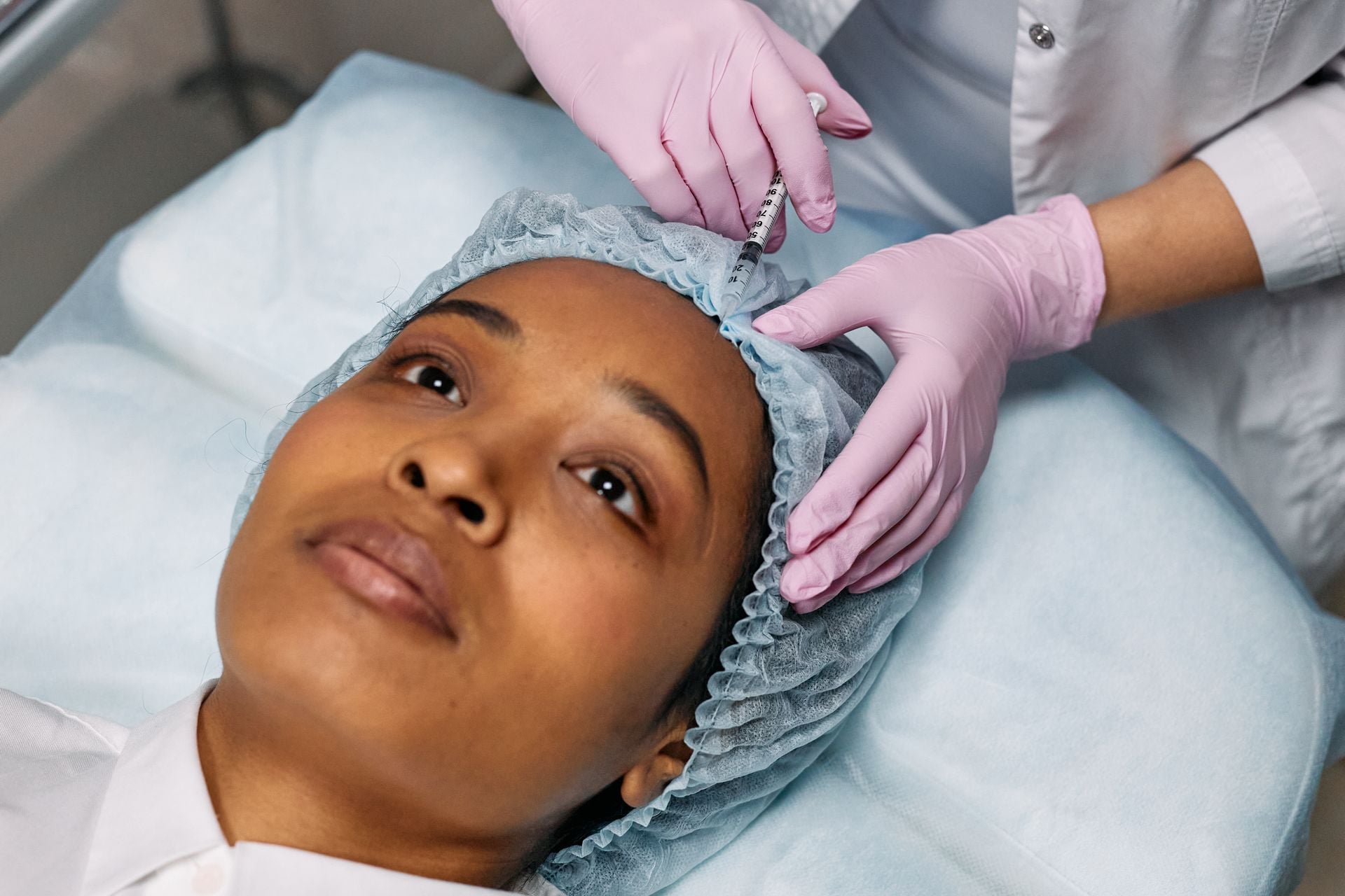 Dermal filler consultation in a med spa treatment room with a provider examining a patient's facial structure.