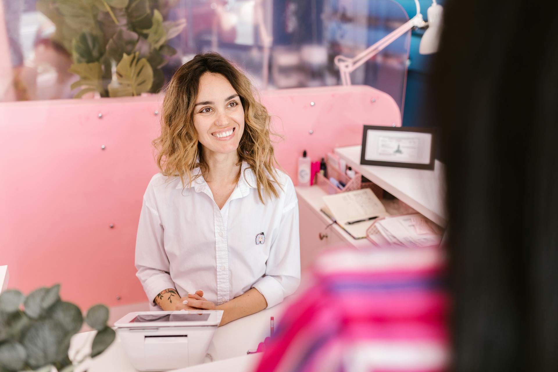 Smiling receptionist at a med spa front desk welcoming clients