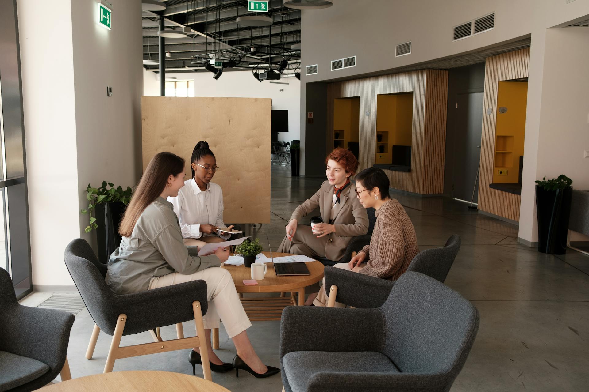 Med spa team meeting with four professionals reviewing business strategy around a conference table